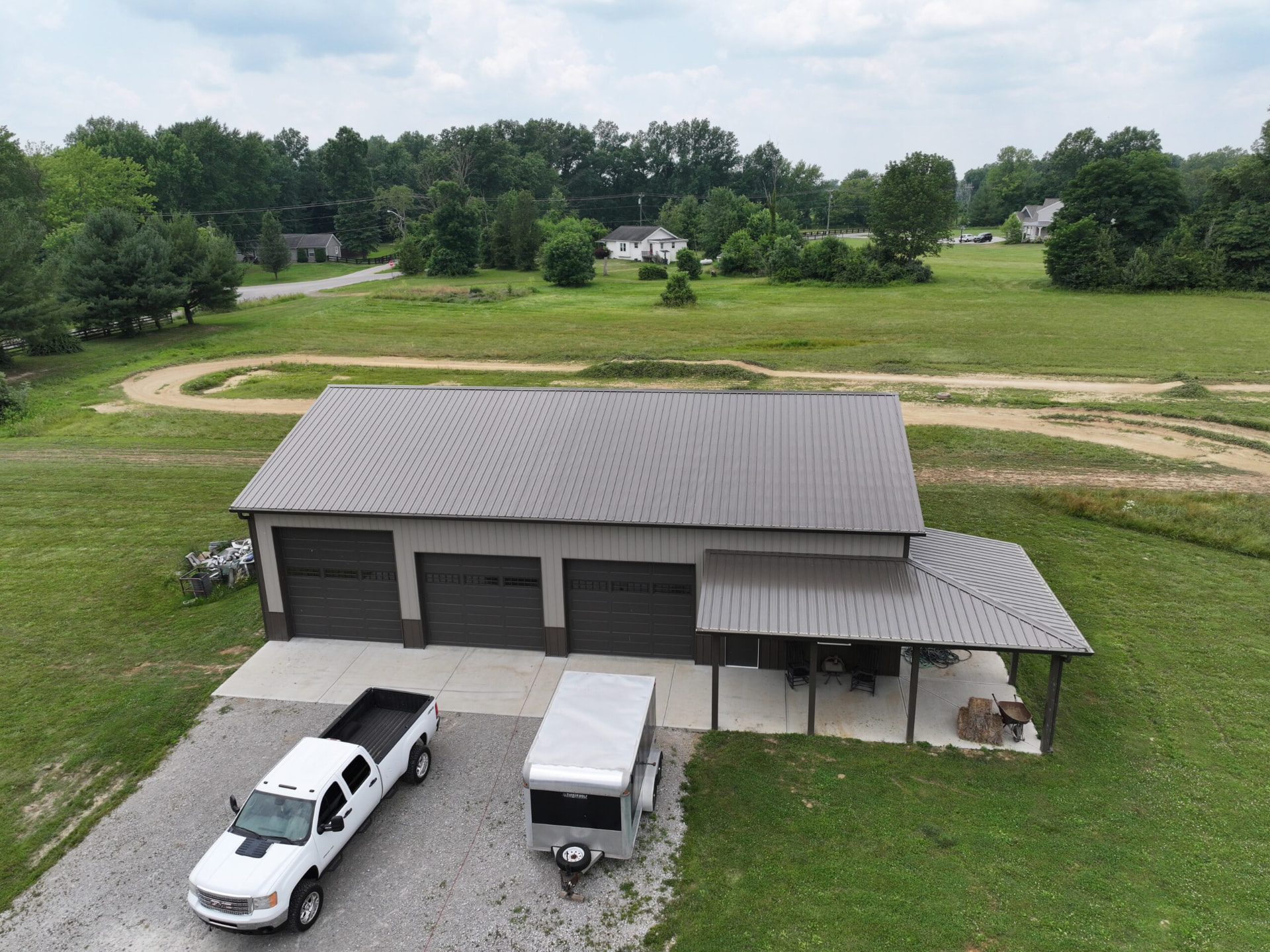 Three bay post frame shop with bronze metal roof and open lean-to on a Southern Ohio farm