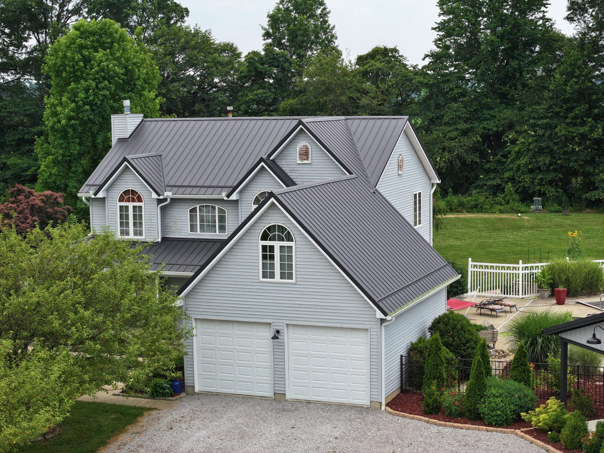 Gray two story home with a dark standing seam metal roof installed by Graber's Construction in Southern Ohio