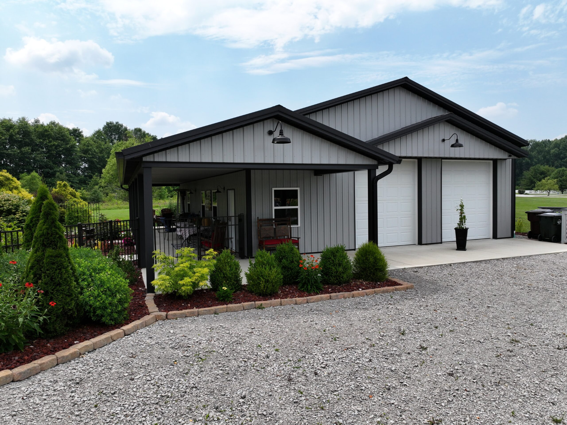 Gray post frame garage with black trim, twin overhead doors, and covered patio in Southern Ohio